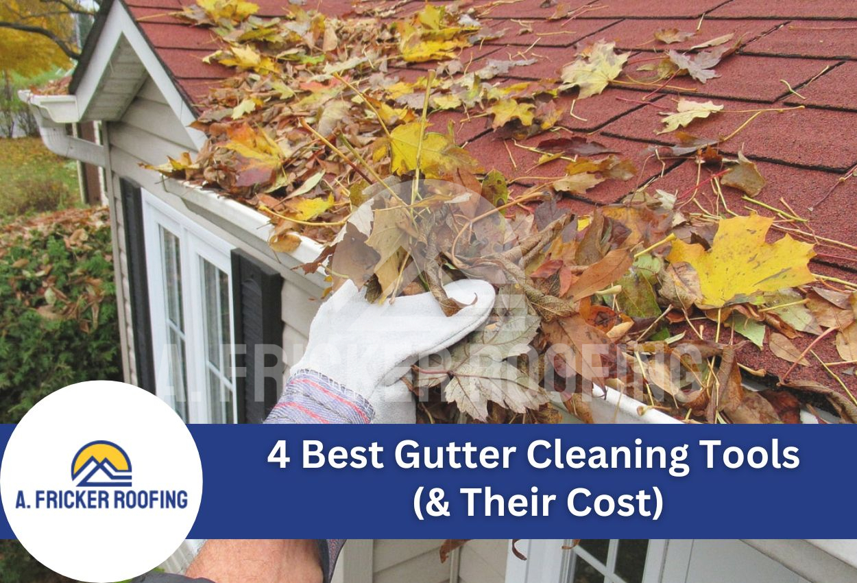Hand cleaning clogged gutter filled with autumn leaves on residential home roof