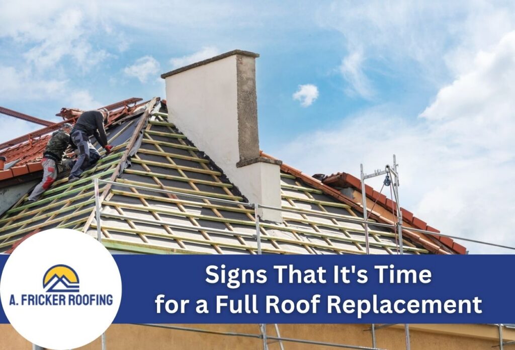 Roofers working on a complete roof replacement atop a residential home.